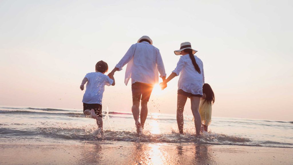 Familia de vacaciones mientras caminan por la playa