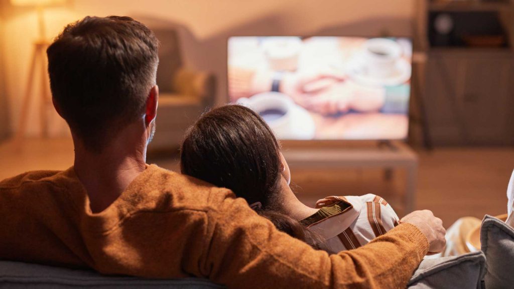 Pareja feliz viendo TV en casa