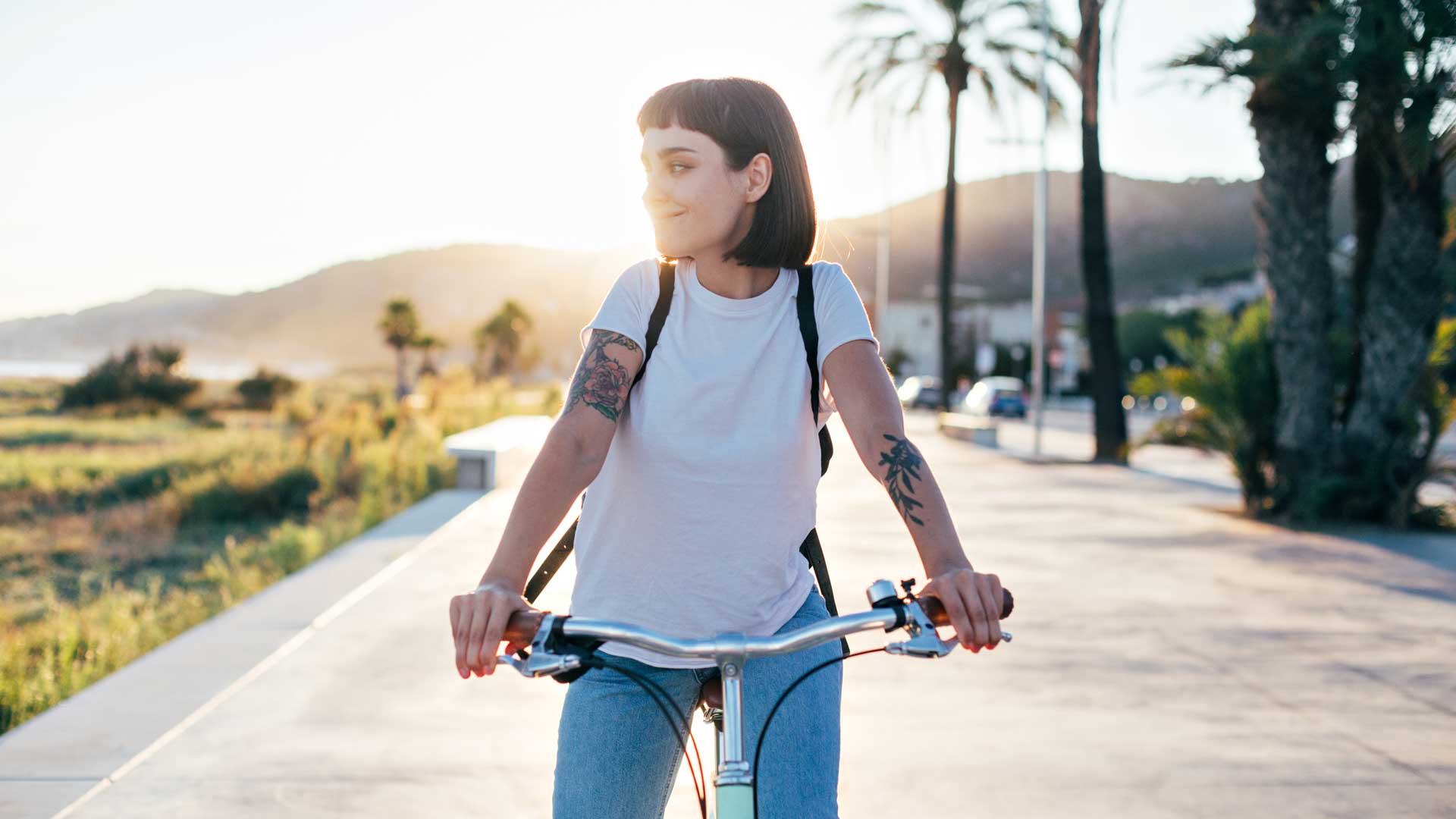 Mujer en bicicleta sonriendo disfrutando el paisaje