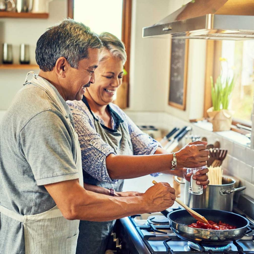 Pareja de adultos mayores cocinando juntos